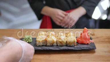 特写-服务员把寿司放在餐厅的桌子上